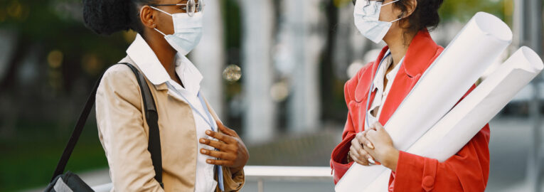 Two women working as architectors on a constraction. People making a decision about plan of a building. Quarantine concept